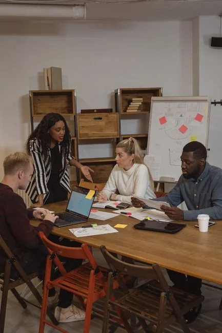 Two coworkers work together on a marketing plan at a whiteboard, centering on user-generated content.